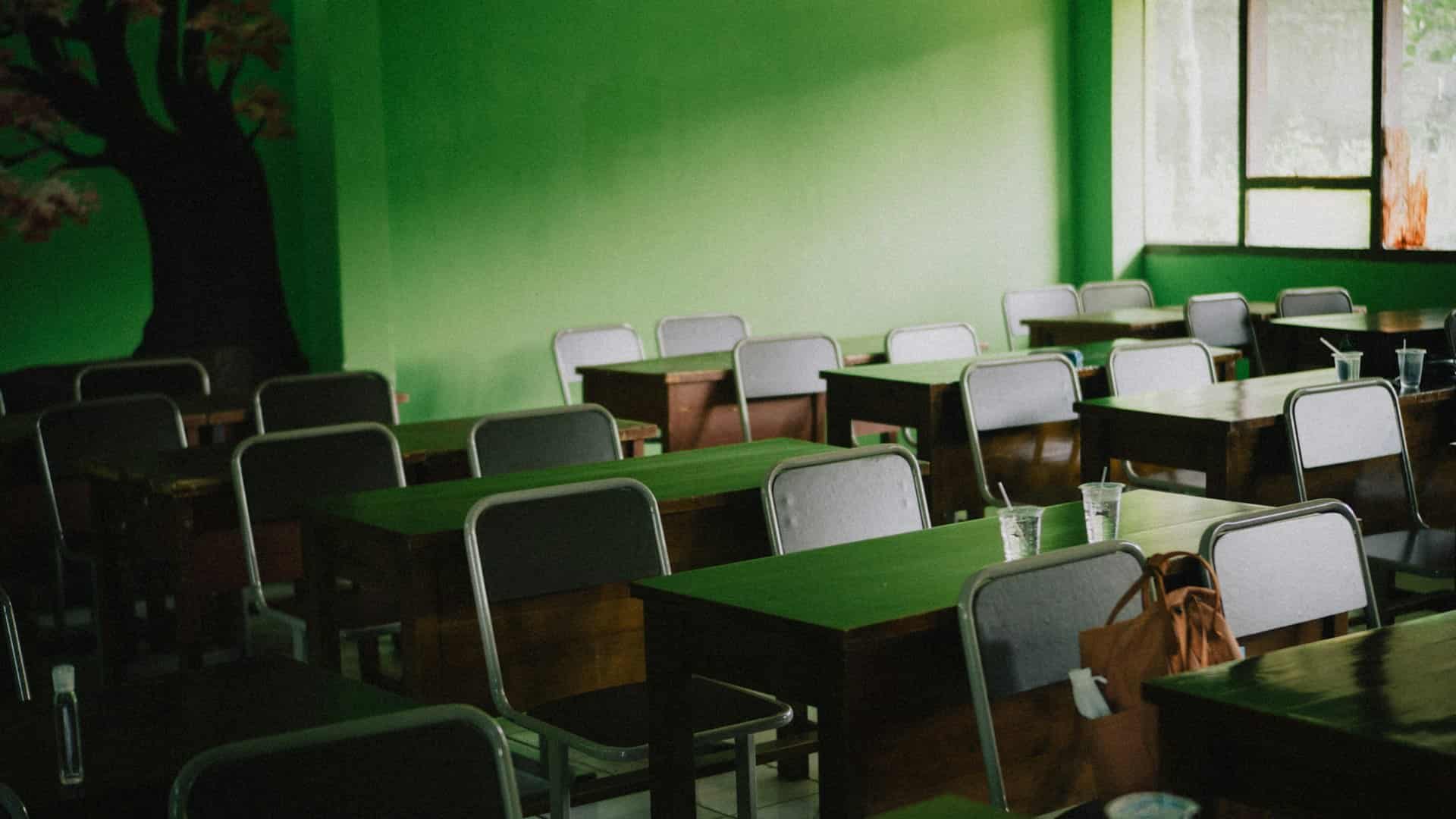 Small green chairs lined up along a wall