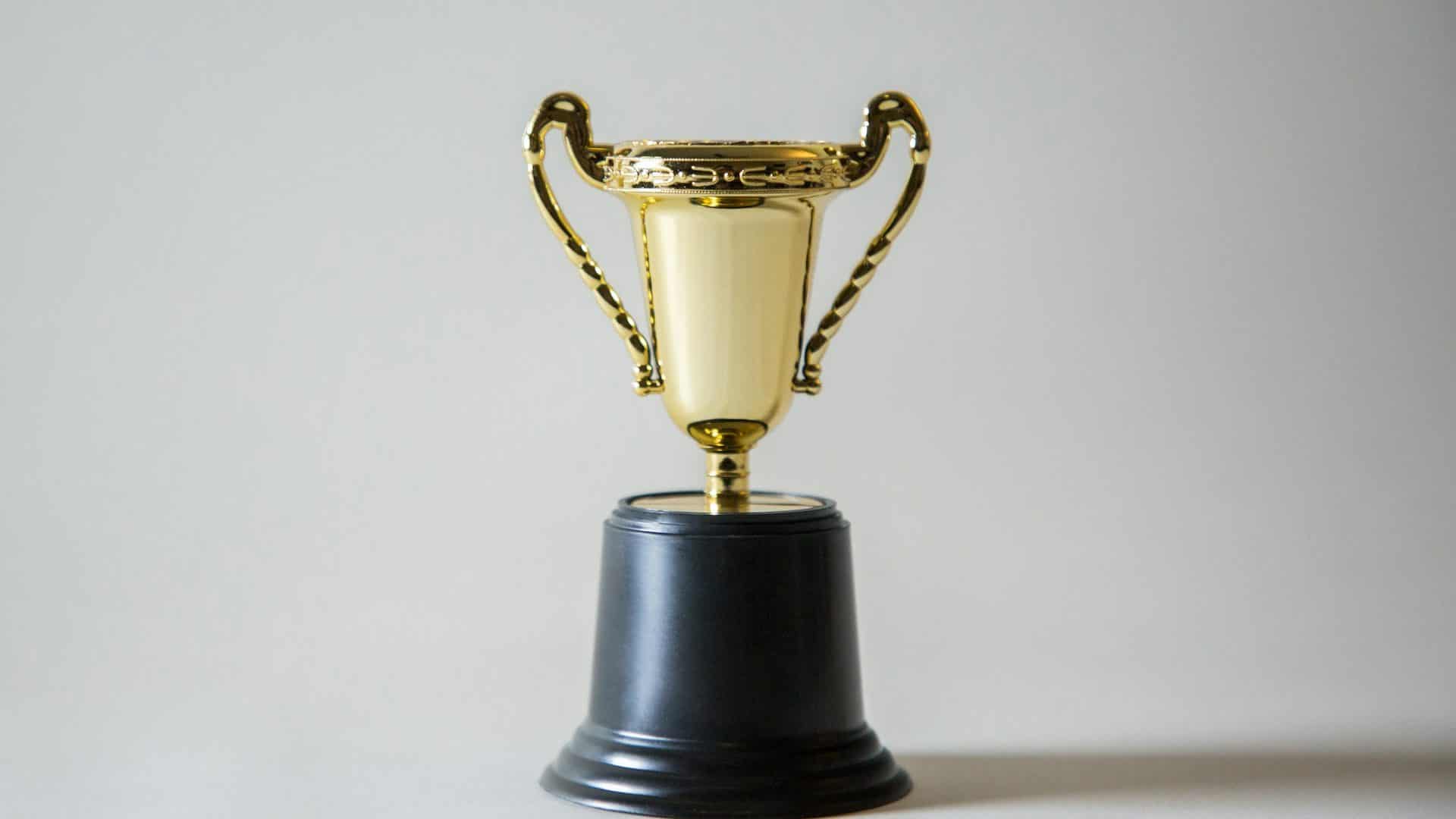 A small golden cup on a black base