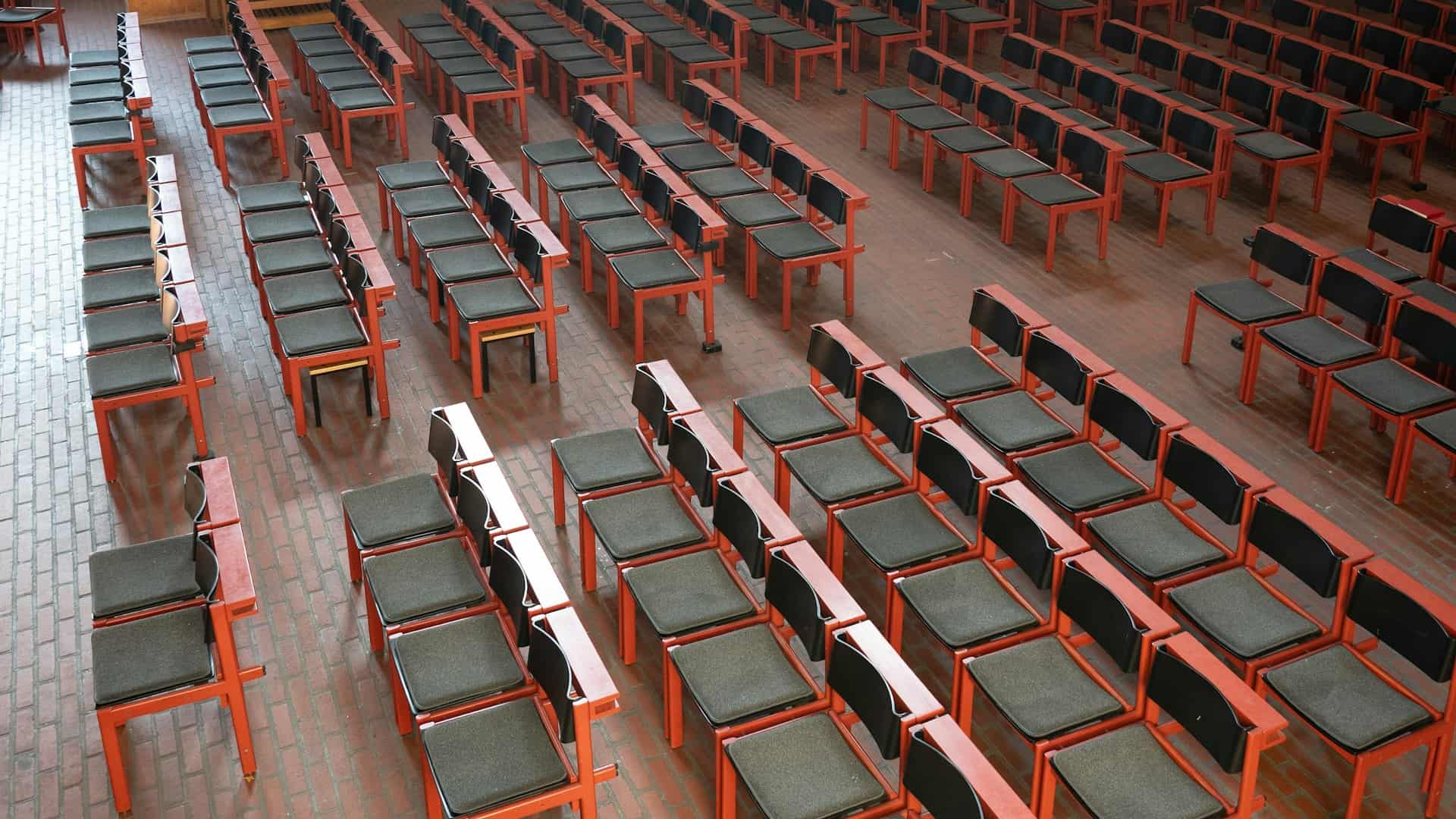 Rows of empty chairs in a large hall, seen from above